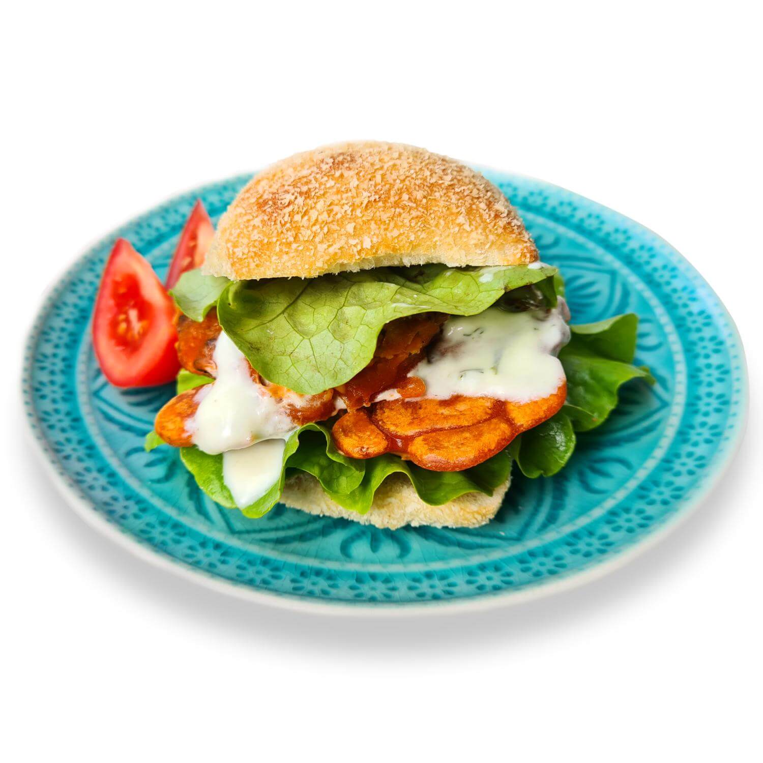 Burger mit Hericium-Filet, Salatblatt und Tomatenschnitze auf blauem Teller